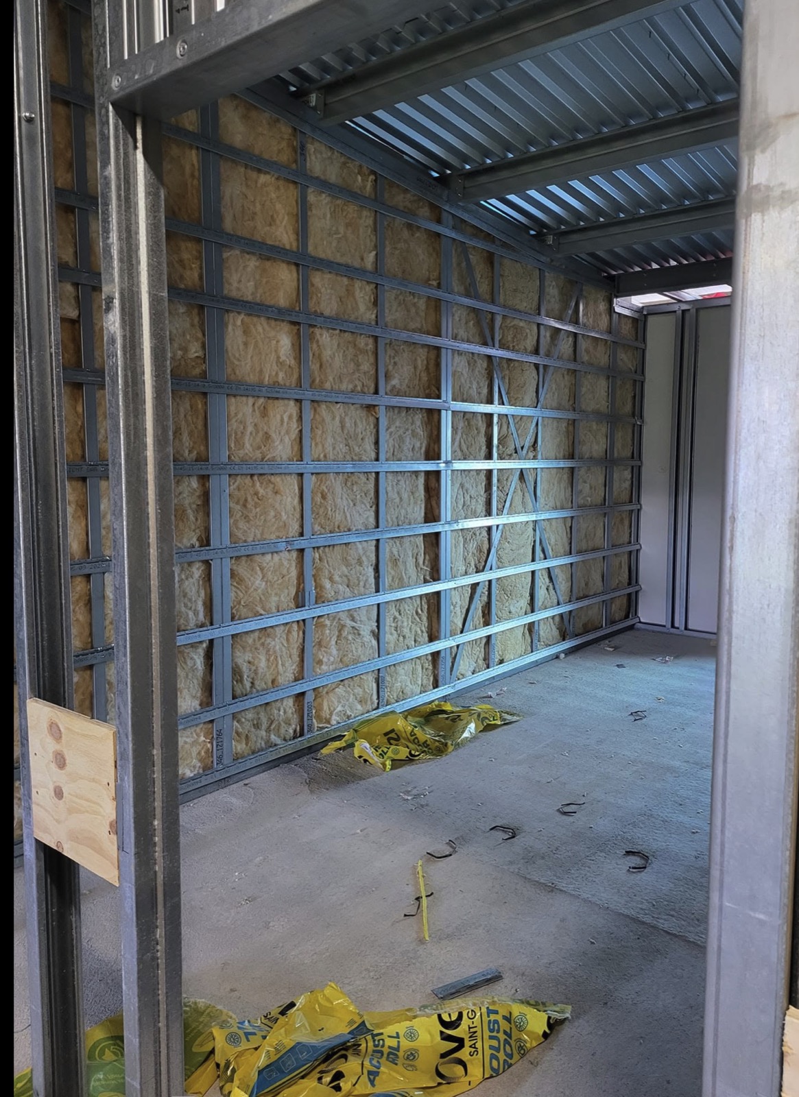 Drylining metal frame wall with insulation in a commercial room