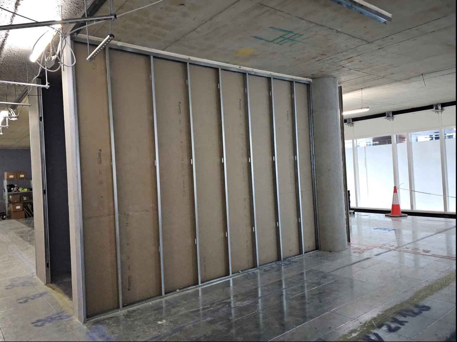 Boarded commercial partition beside glazed opening